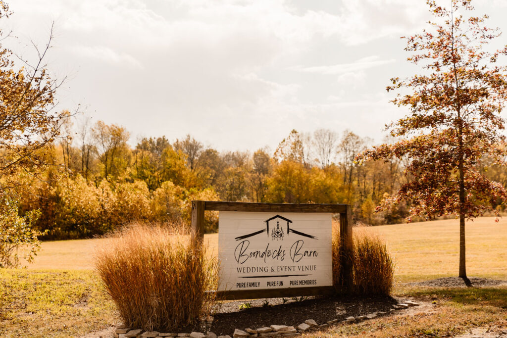 Boondocks Barn wedding venue sign surrounded by fall foliage