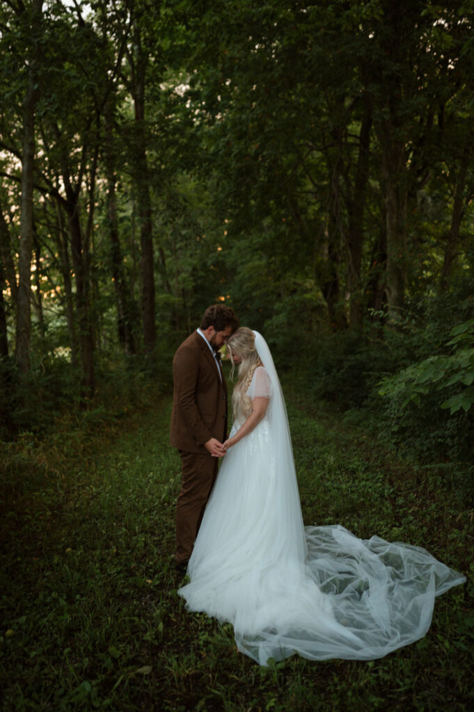 Bride and groom sharing a quiet moment in a wooded area