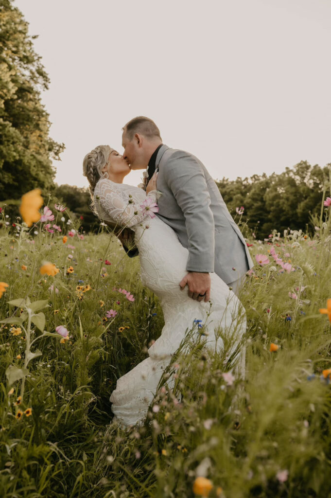 Couple sharing a romantic kiss in a wildflower field