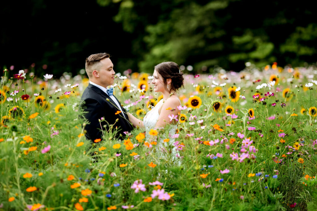 Couple smiling at each other in a vibrant wildflower meadow