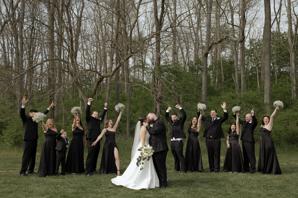 Bride and groom with their bridal party in black dresses and suits