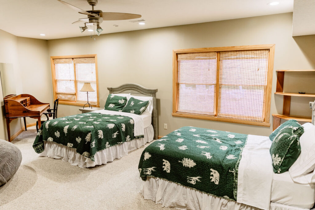 Lodge bedroom with green bedding and rustic furniture in at a wedding locations in Indianapolis