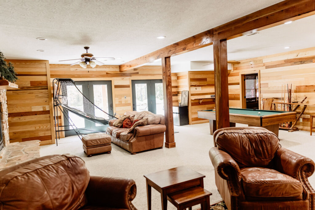 Game room with leather seating, pool table, and cozy wooden interior