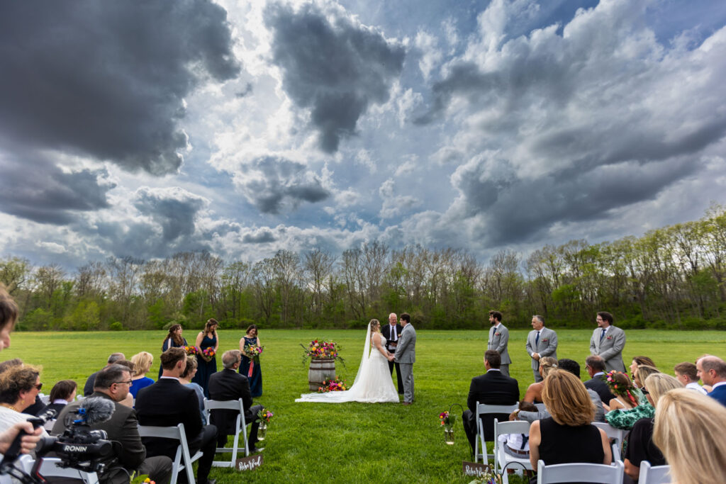 Wide shot of an outdoor wedding ceremony under dramatic skies at a wedding location in Indianapolis