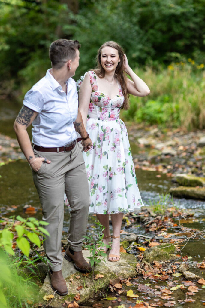 Couple walking on rocks by a stream