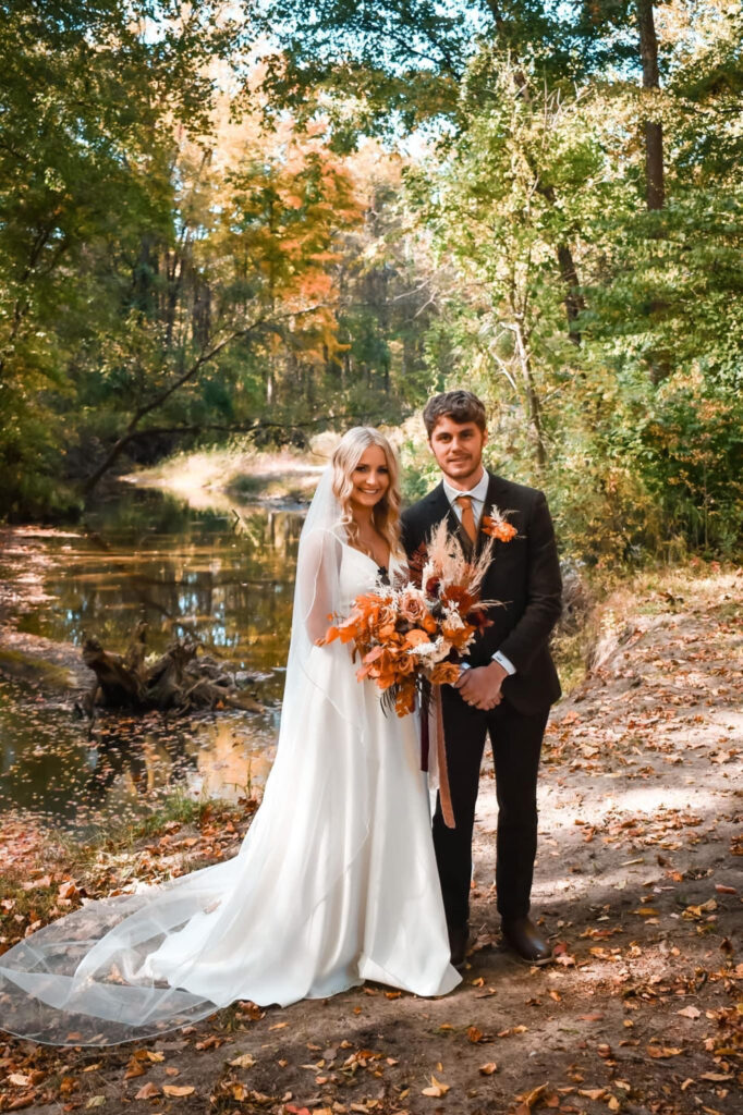 Bride and groom surrounded by colorful fall foliage