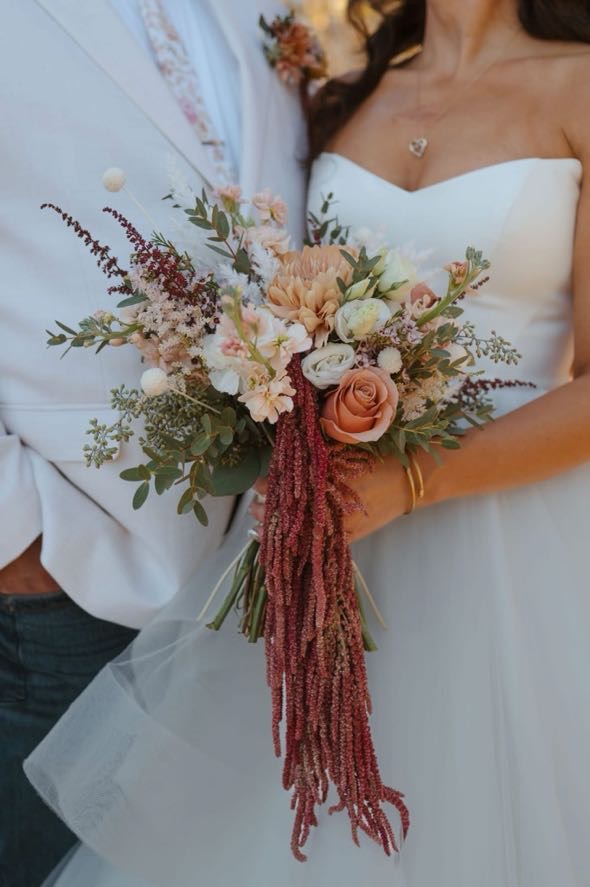 Close-up of bouquet with roses, amaranthus, and greenery at a fall foliage wedding