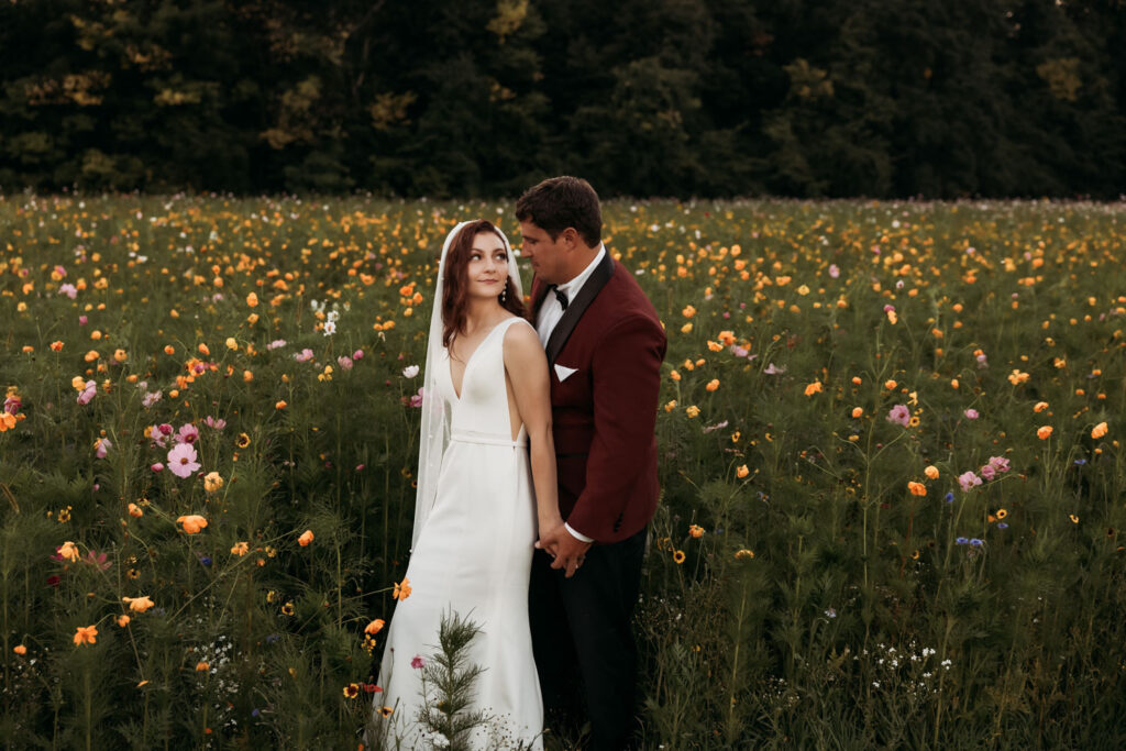 Newlywed couple holding hands while looking at each other on their wildflower wedding at Montgomery Creek Ranch