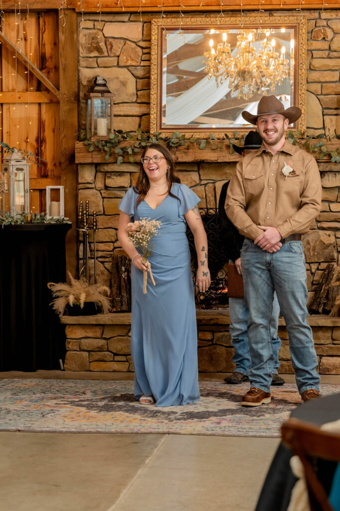 Wedding party standing by the stone fireplace during the ceremony