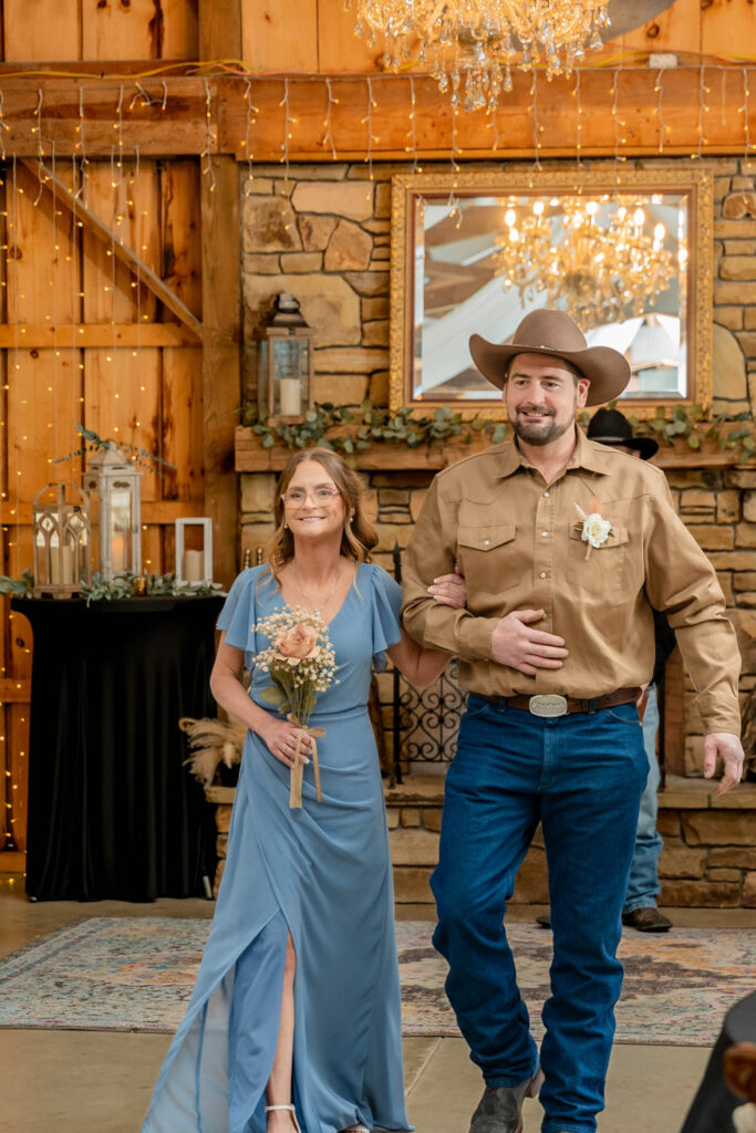 Wedding party walking down the aisle in a rustic venue with fireplace background