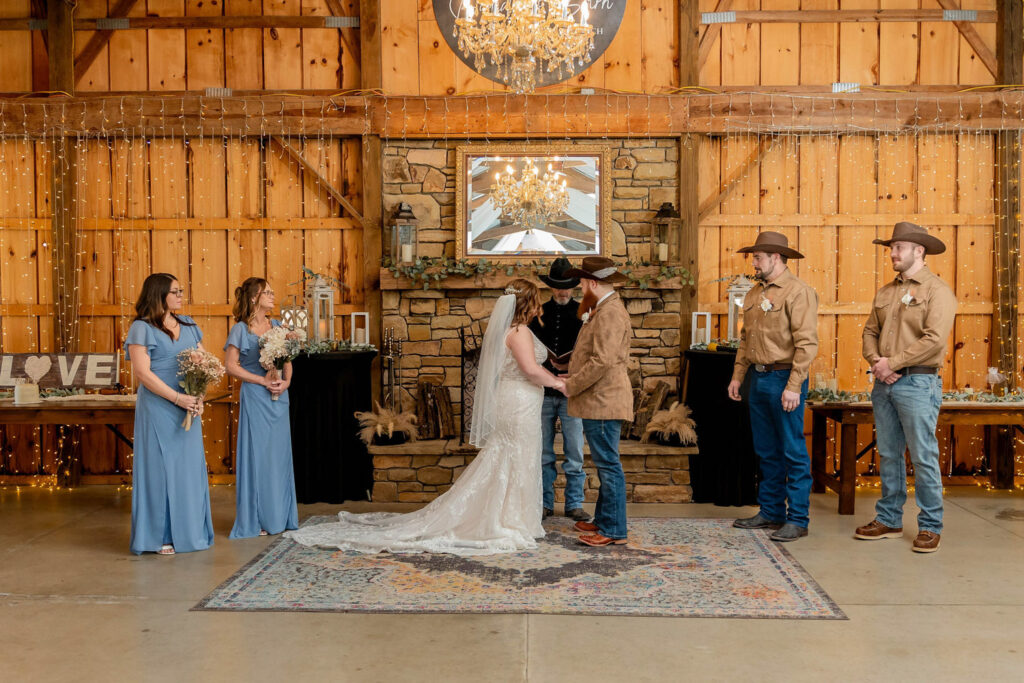 Bride and groom at the altar inside a cozy barn wedding venue