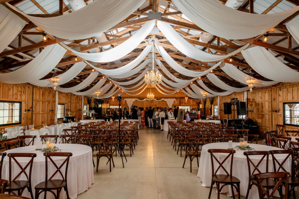 Budget wedding venue reception with rustic barn decor and draped ceilings