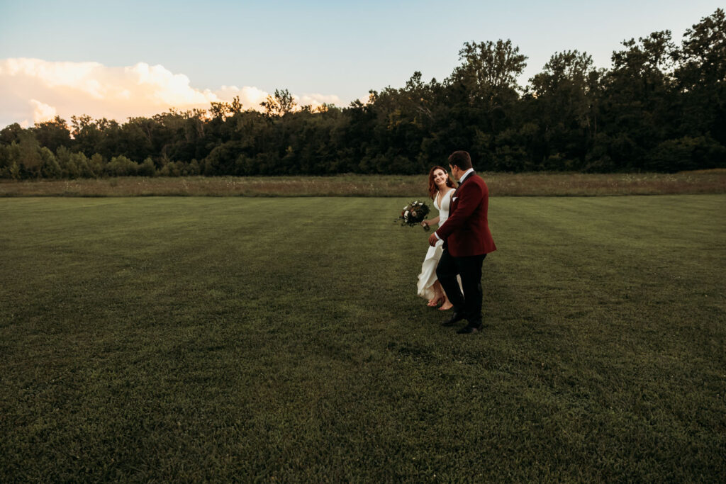 Bride and groom walking across a field at a budget wedding venue