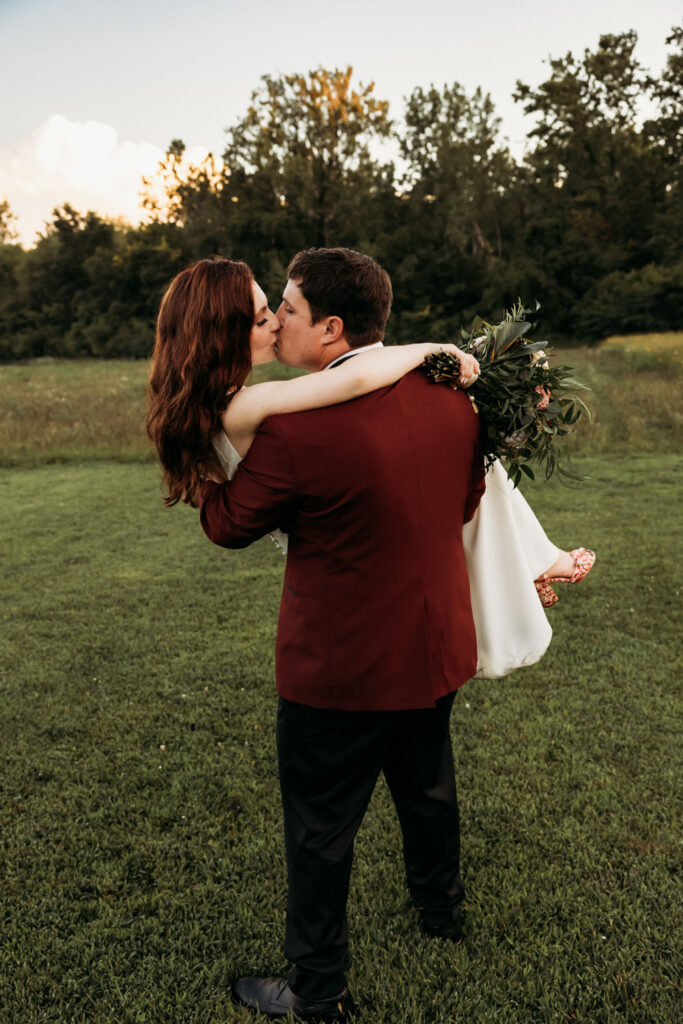Groom carrying bride and kissing at a budget-friendly wedding venue