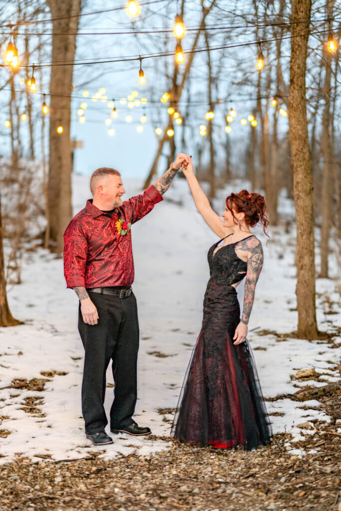 Couple dancing under string lights in the snow showing ambiance tied to venue pricing for weddings