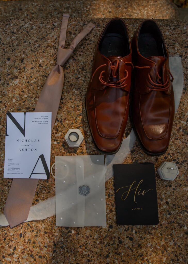 Groom’s shoes and accessories are laid out as part of wedding planning