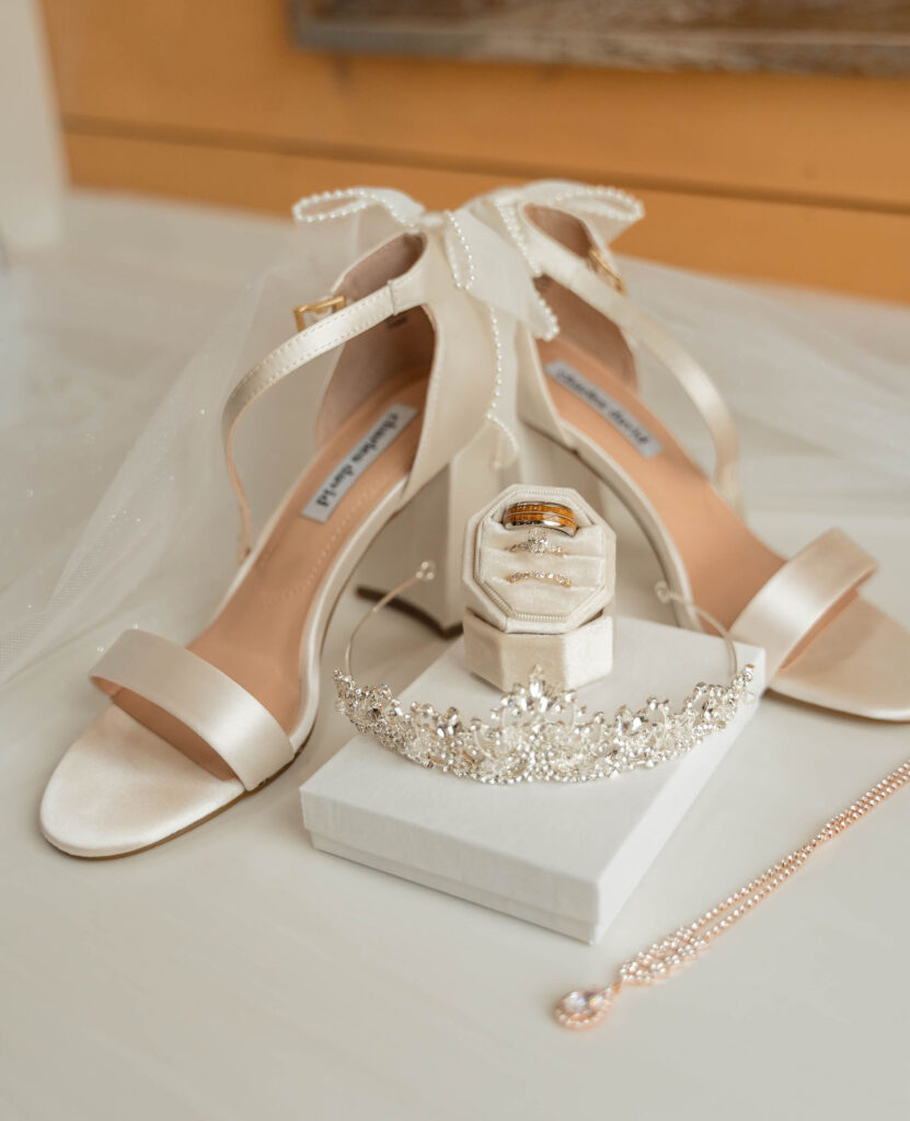Bridal heels, rings, and a tiara are displayed for detail shots