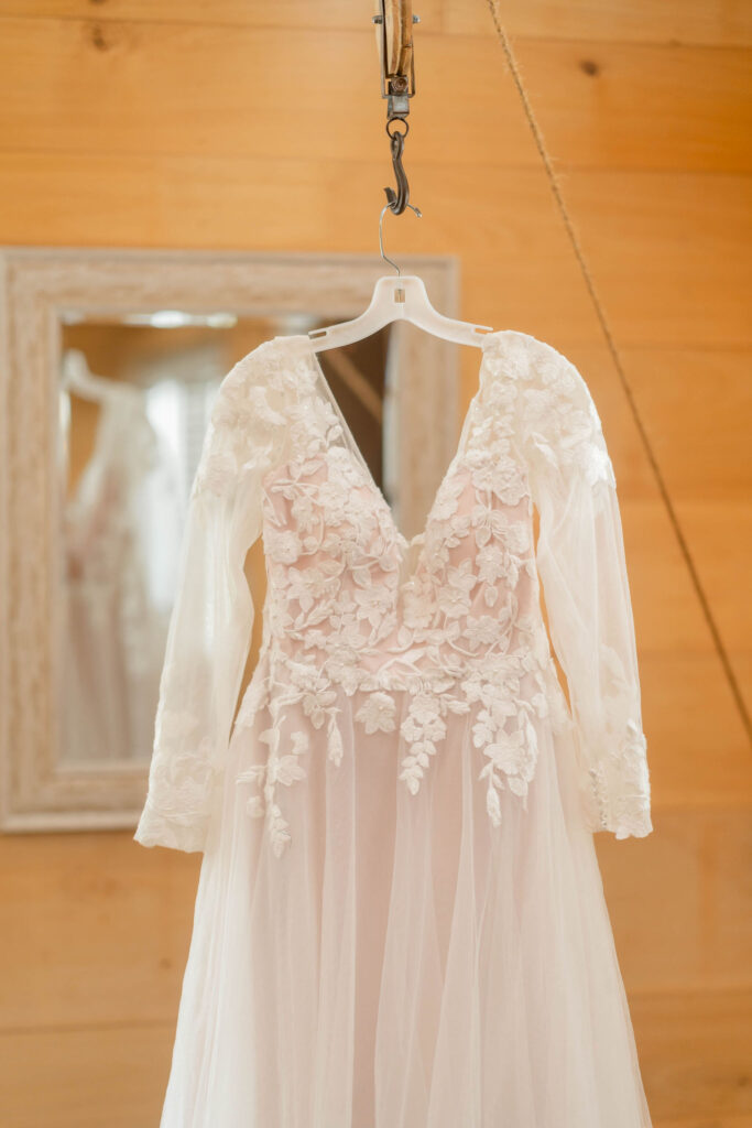 A lace wedding dress hangs in the bridal suite
