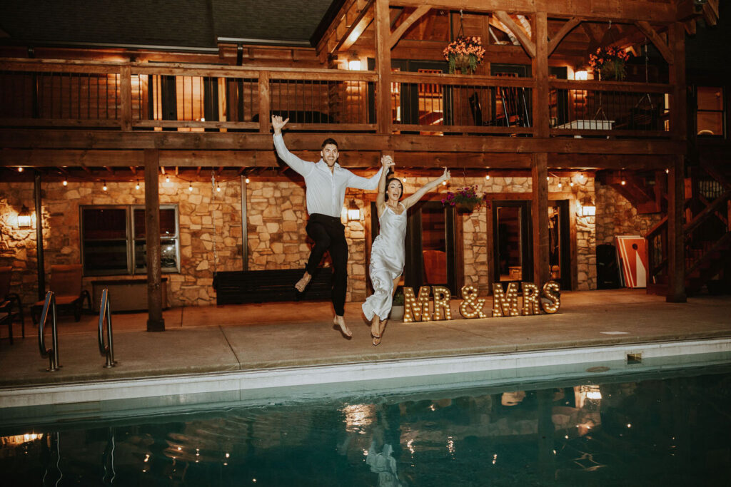 Couple jumping by the pool at Montgomery Creek Ranch lodge at night