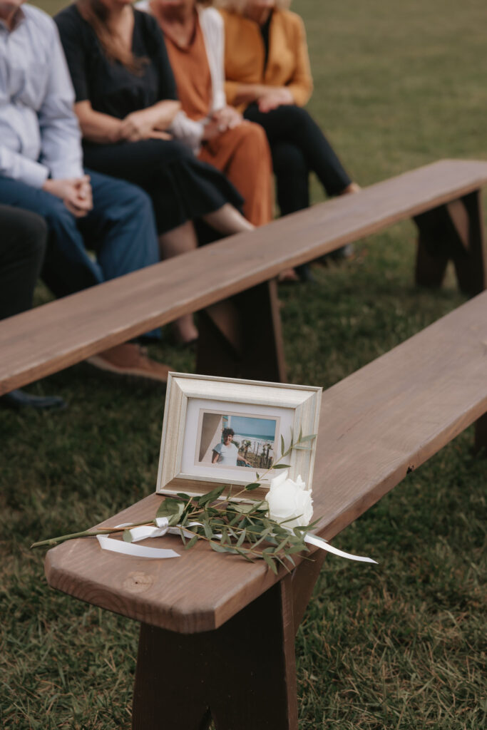 Ceremony seating with framed memorial photo and greenery
