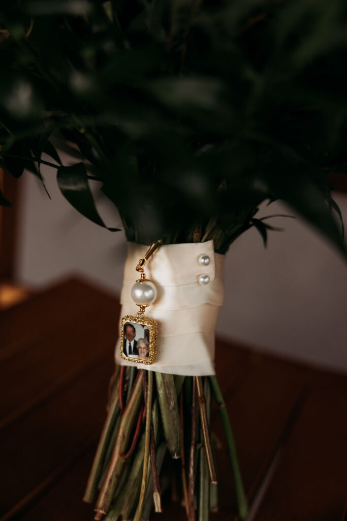 Wedding bouquet with memorial photo charm attached to ribbon