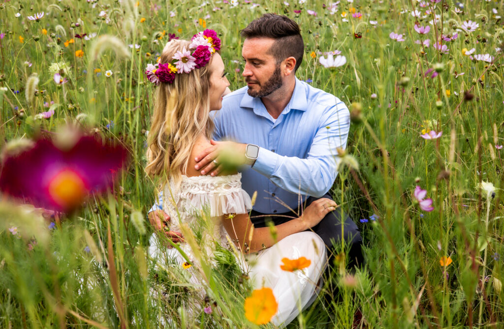 Couple sitting together in a colorful wildflower field