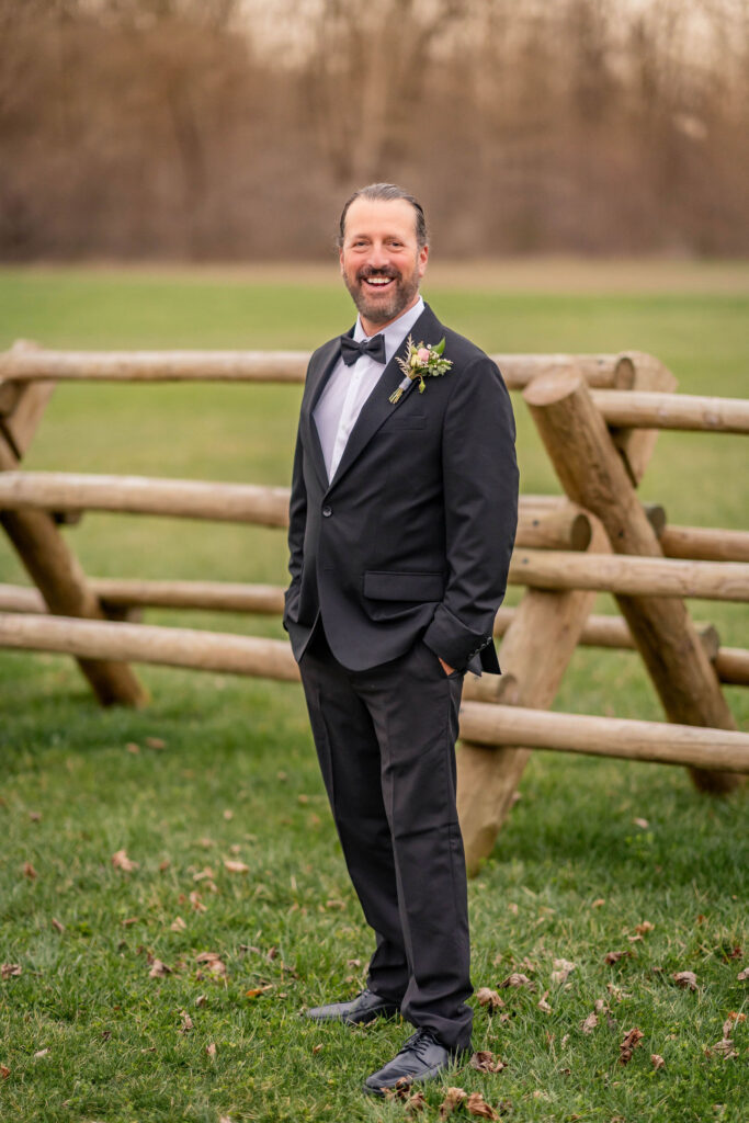 Groom portrait by fence