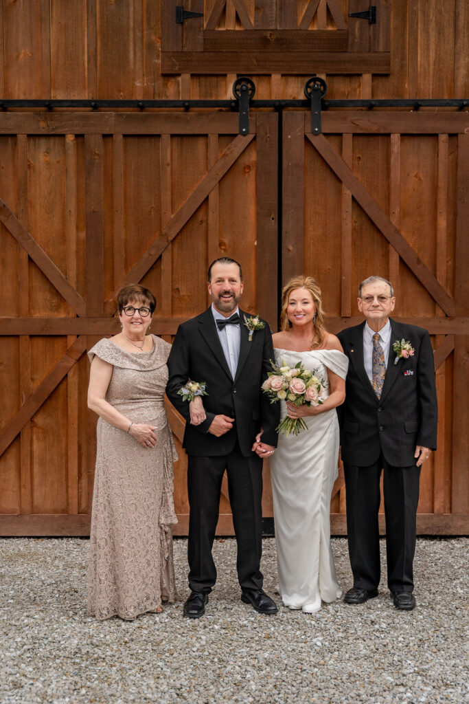 Couple with family outside barn